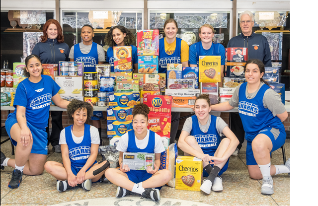 Suffolk Women's Basketball team poses with donated food