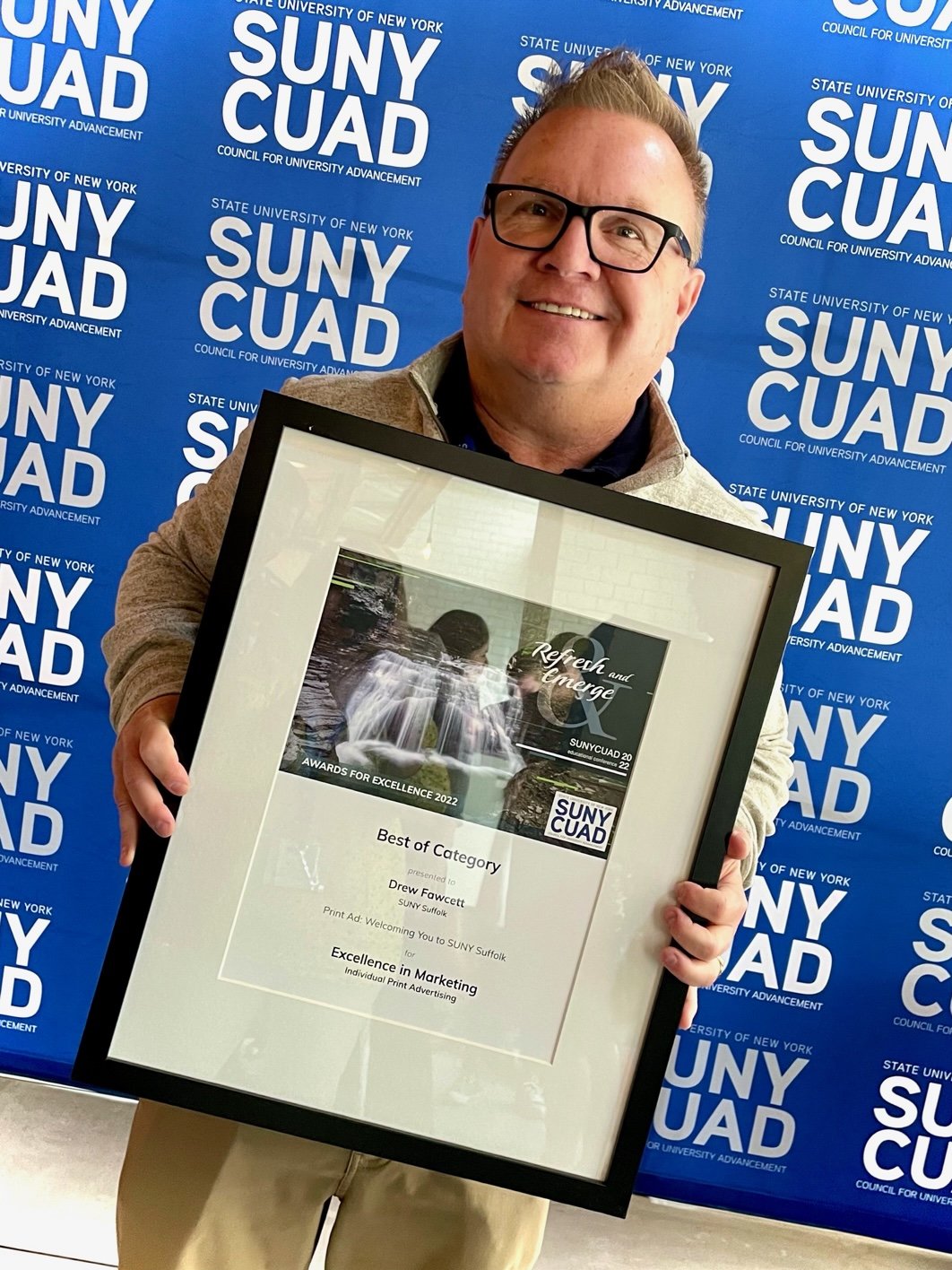 Photo of Drew Fawcett winning the SUNY CUAD Award for excellence in marketing.