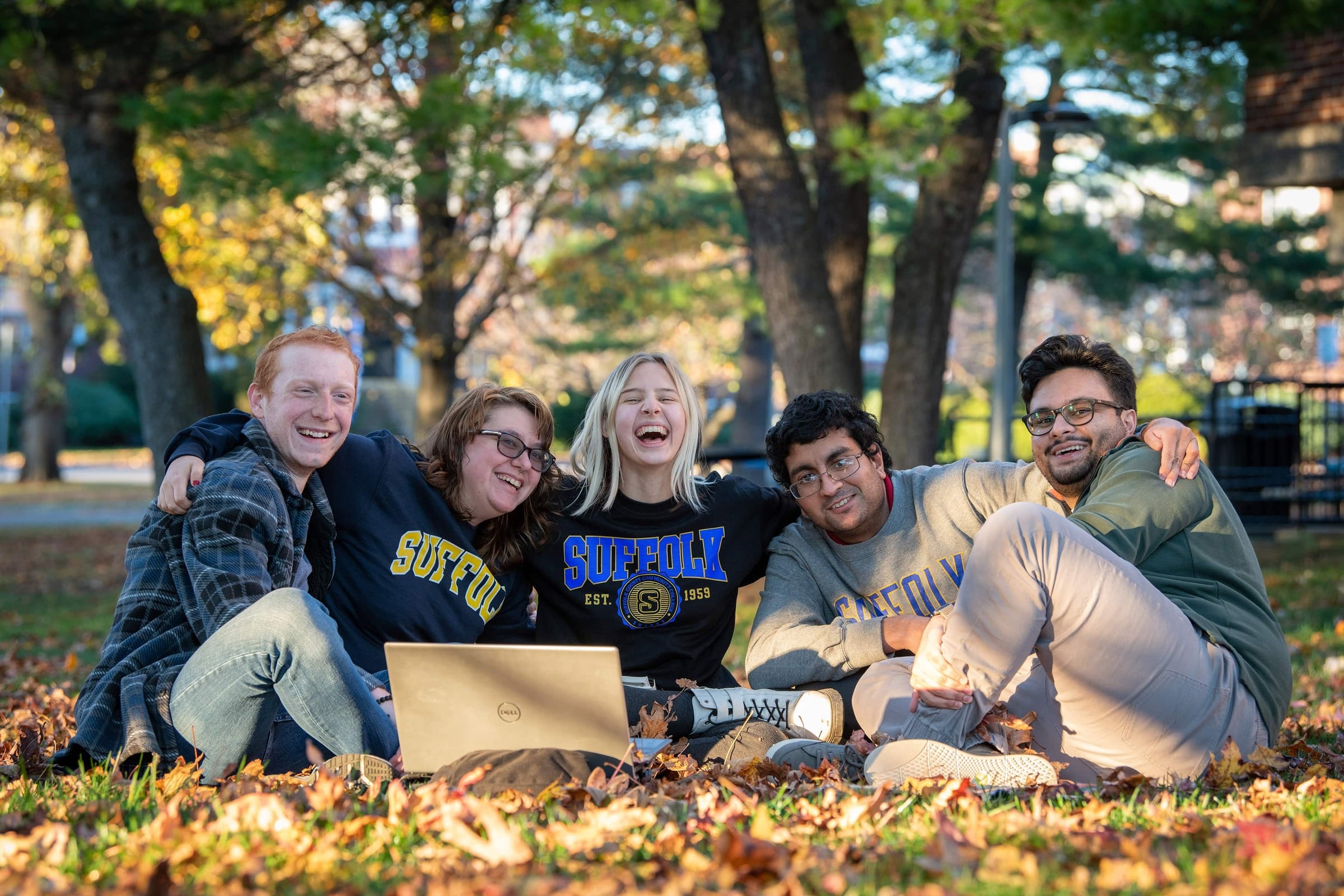 Five students at Suffolk sitting on the grass