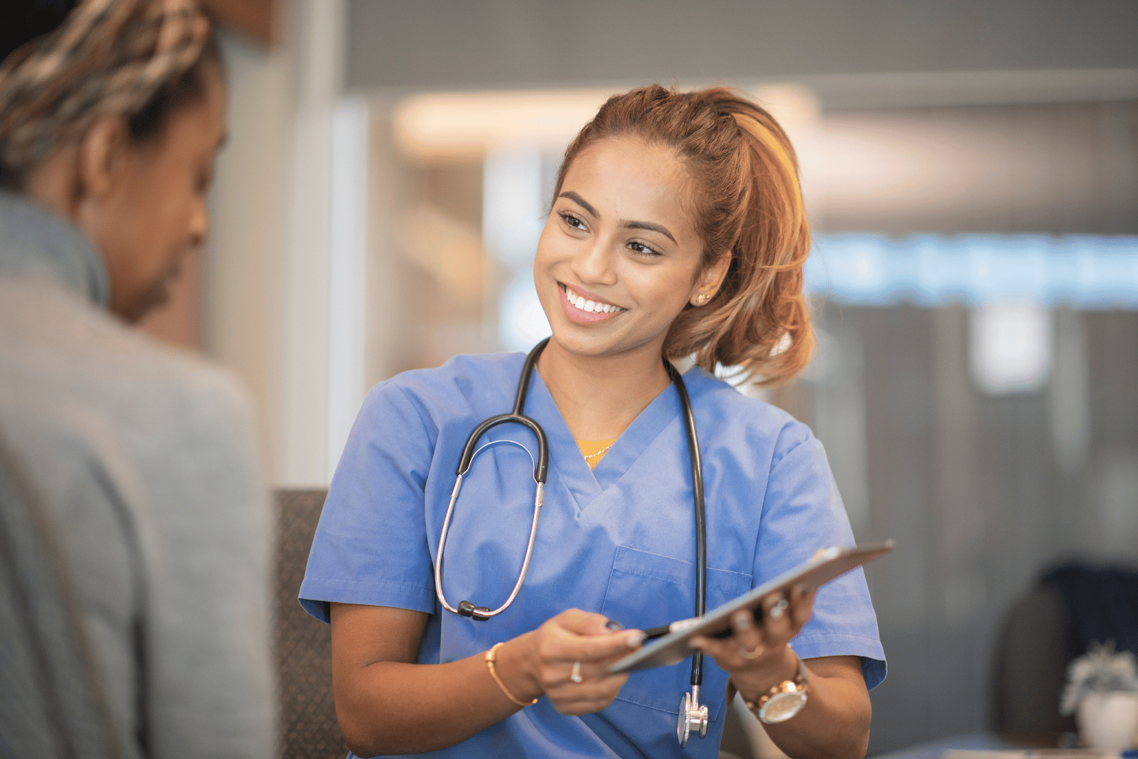 Doctor holding a clipboard talking to a patient