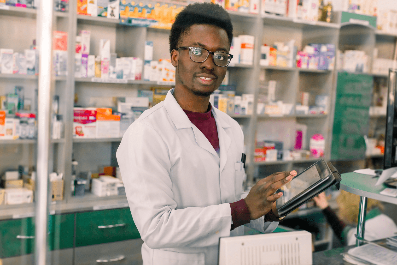 Pharmacist smiling with a tablet in his hand
