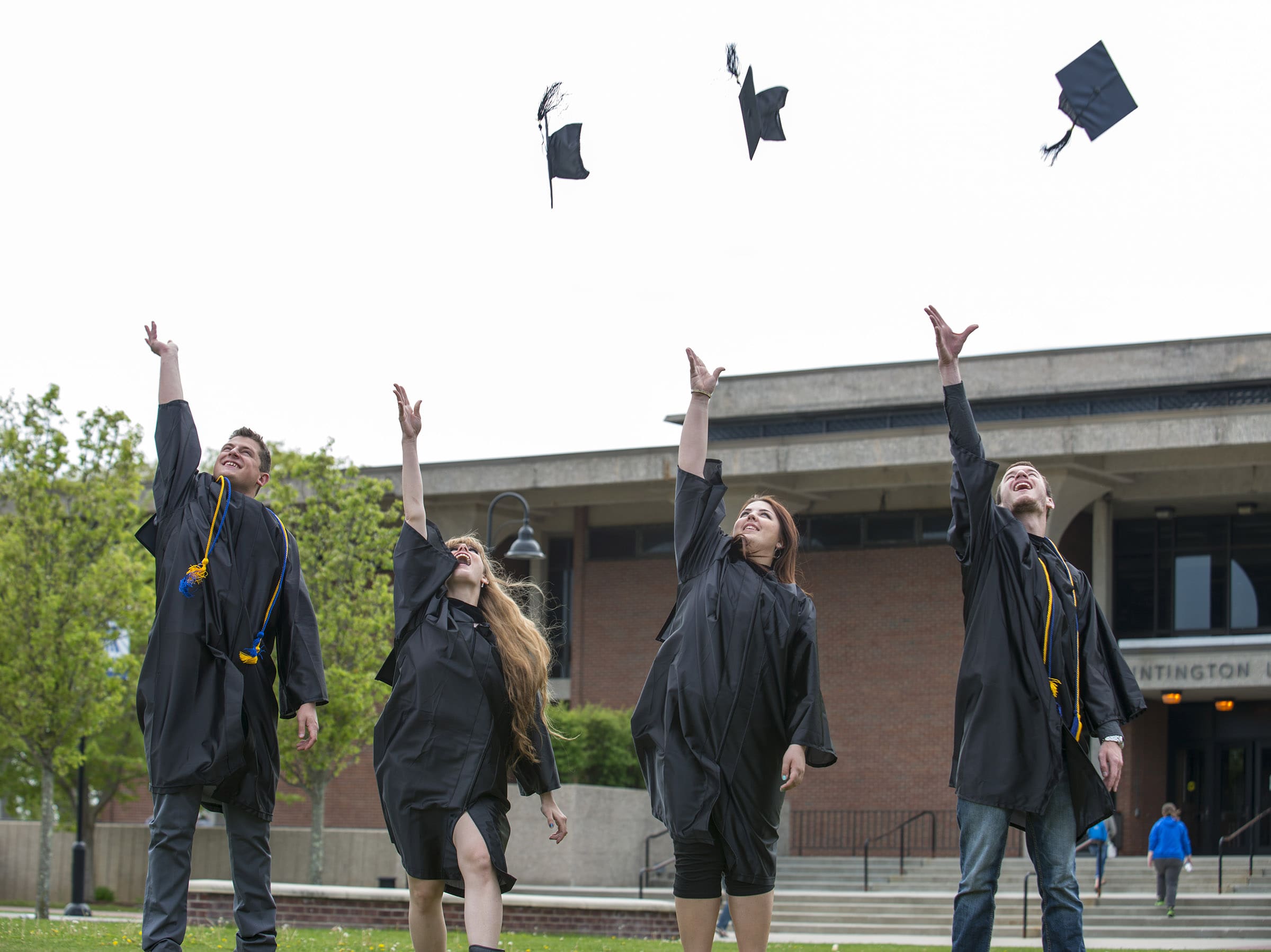 Students at the graduation ceremony throwing their hats in the air.