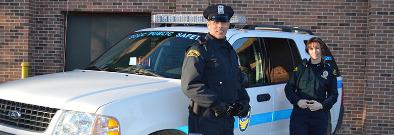 Two public safety officers standing in front of a public safety vehicle