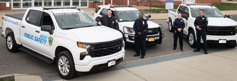 Two public safety officers standing in front of a public safety vehicle