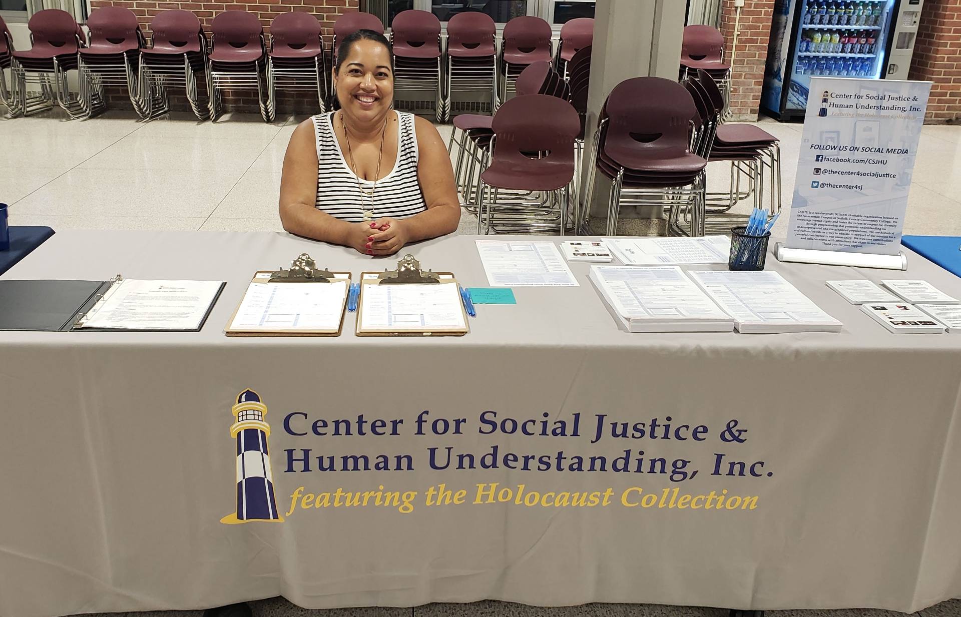 Photo of Jill Santiago in the Babylon Student Center at a desk.