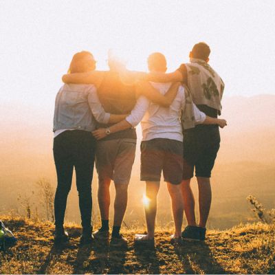 Group of students supporting each other looking at a sunset