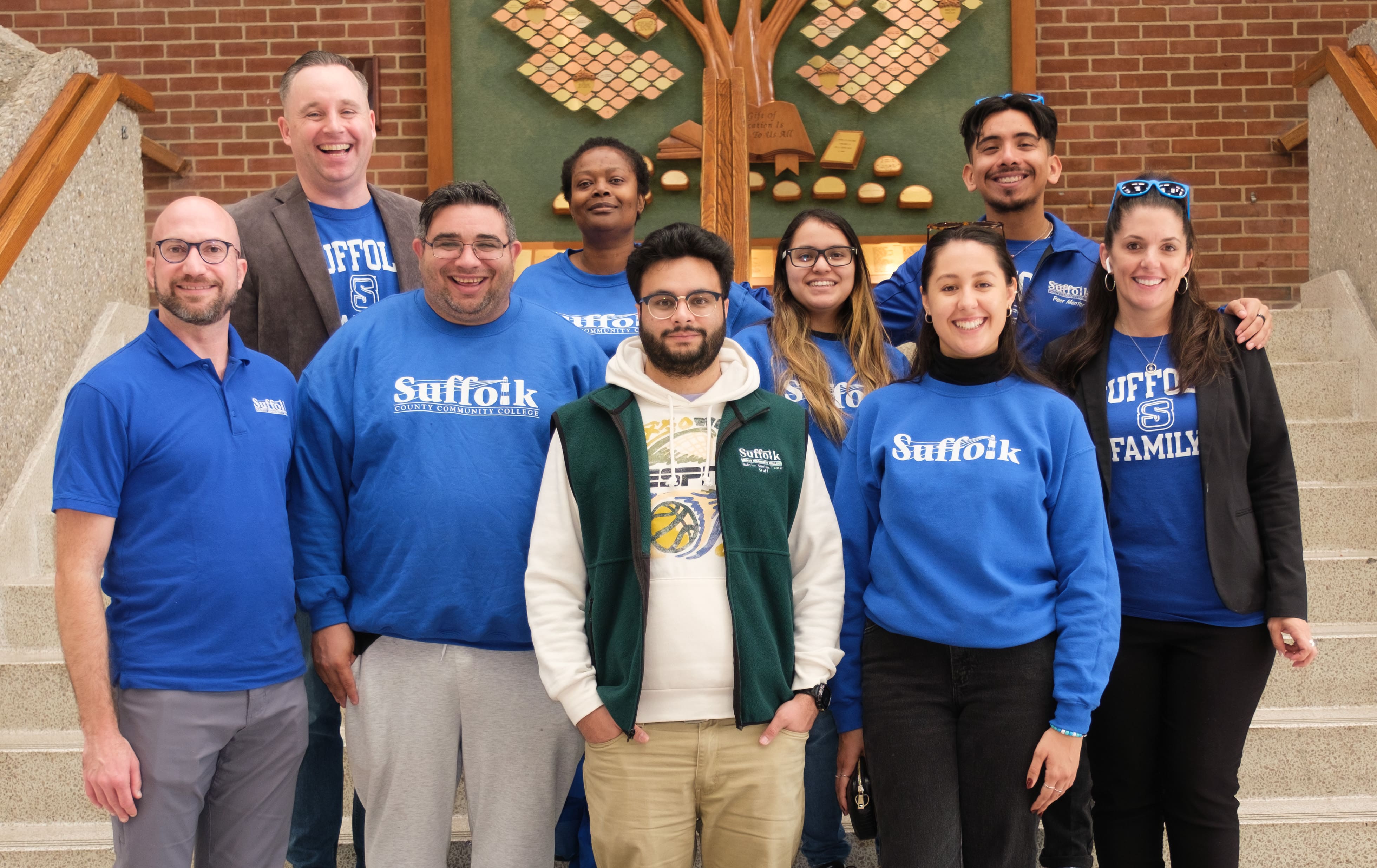 Image of a group of 9 people in blue Suffolk shirts