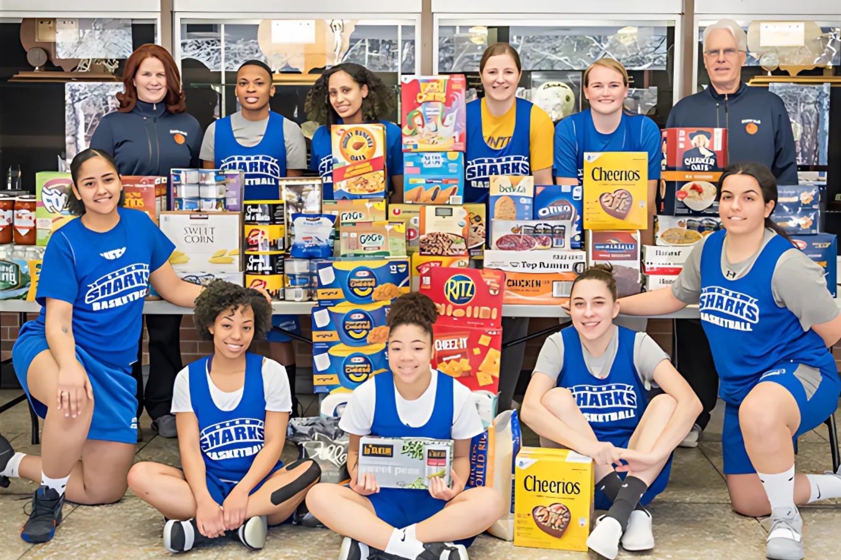 Suffolk students holding up food donated at the food pantry