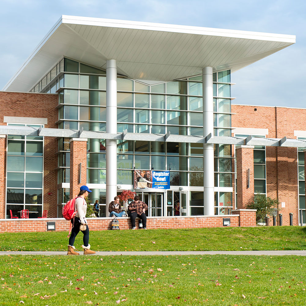 A college building on Eastern campus with a couple of students in front.