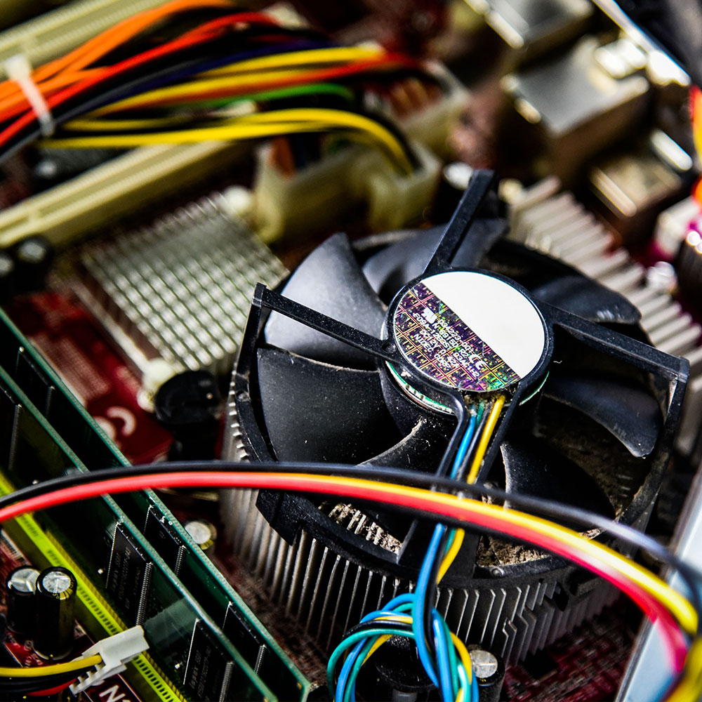 Close-up shot of computer hardware (a fan, memory and wires).