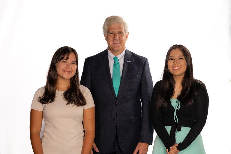 Suffolk County Community College President Dr. Edward Bonahue, center, congratulates scholarship winners Amay Mata, at left and Emily Luca, right.