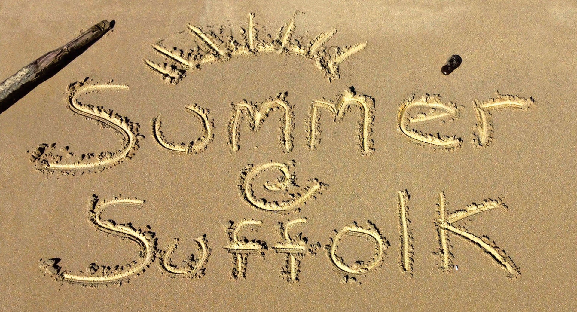 Summer Session at Suffolk written in the sand